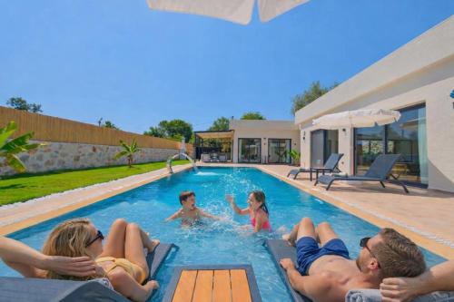 a group of people laying in a swimming pool at villa tera Private Pool & jacuzzi in Fethiye