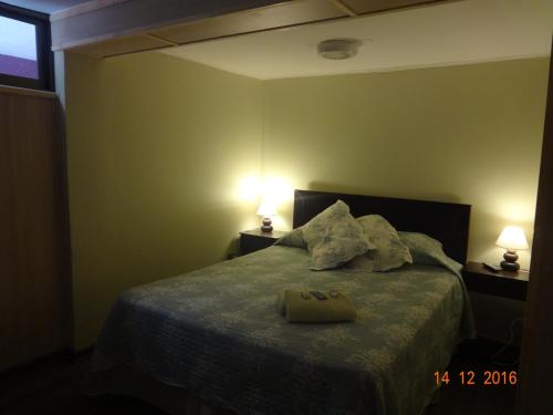 a bedroom with a bed with two lamps on it at Sentir Patagonia in Viña del Mar