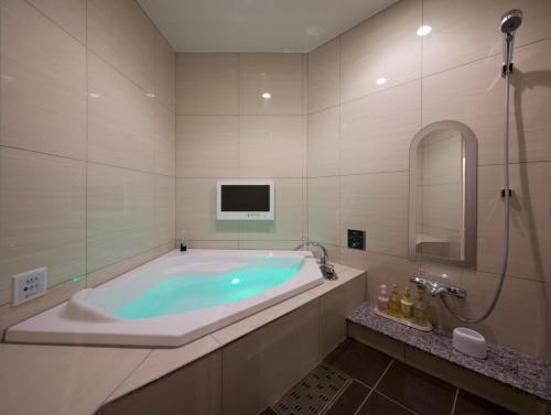 Miyoshi的住宿－珍寶豪華現代酒店（僅限成人），一间带电视和电视的浴缸的浴室