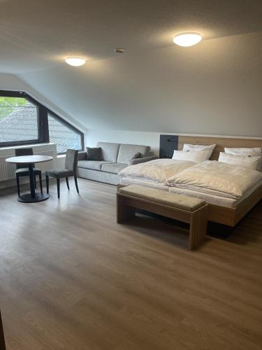 a bedroom with a bed and a couch and a table at Hotel Rammelkamp in Nordhorn