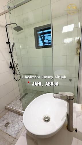 a bathroom with a toilet and a glass shower at AA Luxury Apartments in Abuja