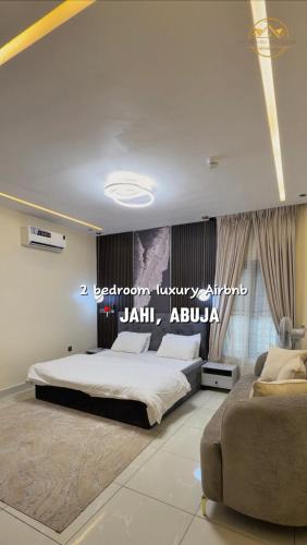 a bedroom with a large bed and a couch at AA Luxury Apartments in Abuja