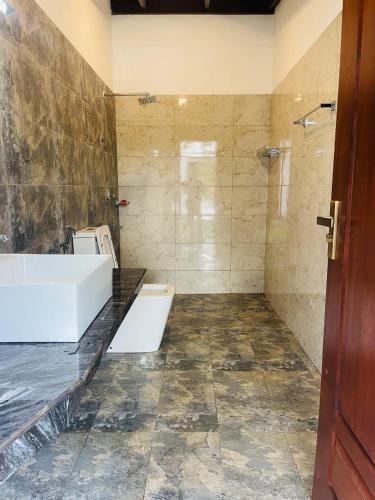 a bathroom with a tub and a sink and a shower at Rainforest Mount Villa in Nelluwa