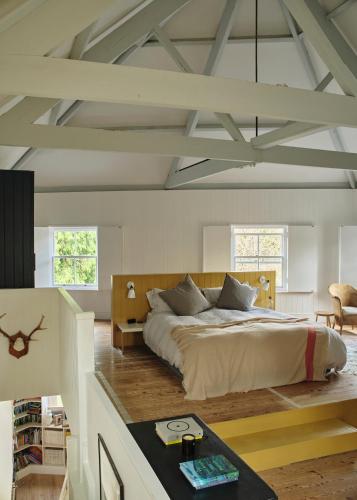 a bedroom with a large bed and a table at Historic Brewery Cottage in Dorset Village Sleeps 10 in Fontmell Magna