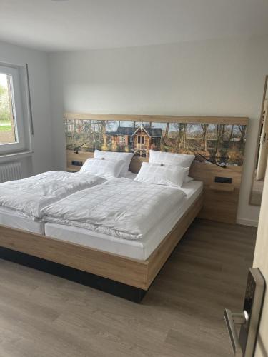 a bedroom with a large bed with white sheets and pillows at Hotel Rammelkamp in Nordhorn
