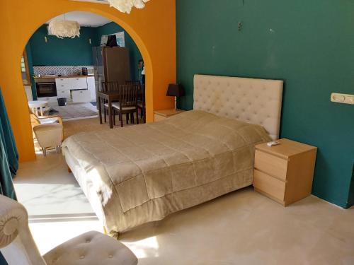a bedroom with a large bed and a kitchen at Casa Papaver Relax Appartement in Coín