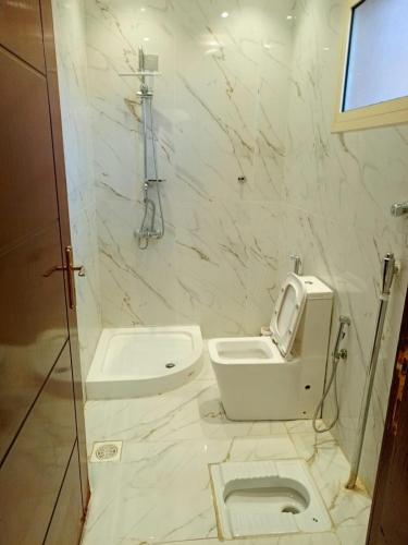 a white bathroom with a toilet and a sink at شالية سحاب in Rayyis