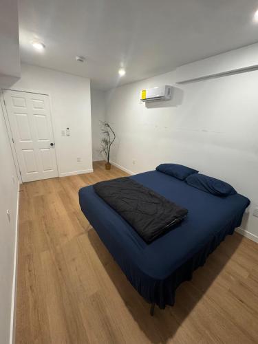 a bedroom with a bed with a blue blanket on it at Vernon Vibes in Los Angeles