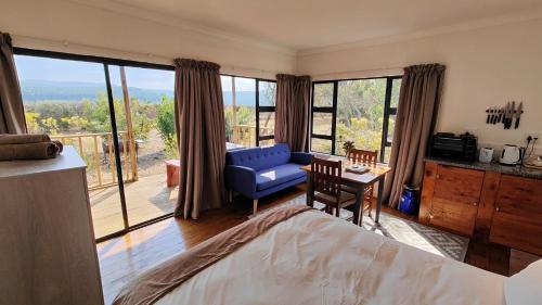 a bedroom with a bed and a large window with a view at The Edge Mountain Retreat in Hogsback