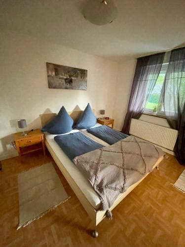 a bedroom with a large bed with blue pillows at Ferienwohnung Mutter in Schluchsee