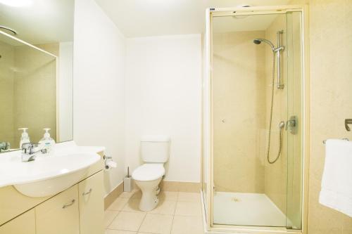 a bathroom with a shower and a toilet and a sink at Exclusive Stays - Southpoint in Melbourne