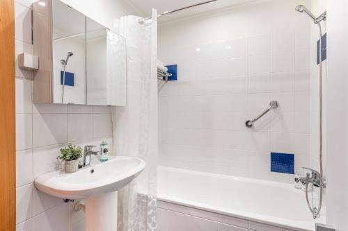 a white bathroom with a sink and a shower at Sapphire Scape Near Airport Madeira Santa Cruz in Gaula