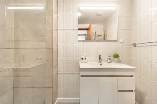 a white bathroom with a sink and a mirror at Emerald Scape Garajau Madeira Cristo Rei Area in Caniço