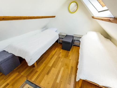 a attic bedroom with two beds and a window at Snug Holiday Home in Nieuwvliet in Nieuwvliet