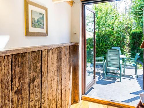 a sliding glass door leading to a patio with chairs at Snug Holiday Home in Nieuwvliet in Nieuwvliet