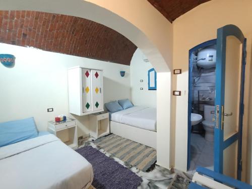 a small room with two beds and a bathroom at malindy KA nubian houseماليندى كا in Aswan