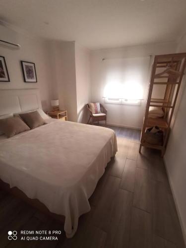 a bedroom with a bed and a chair and a window at SUNSHINE GROUP in Málaga