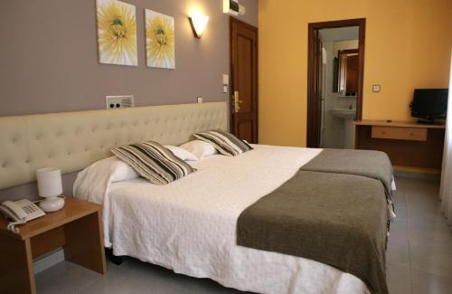 A bed or beds in a room at Hotel Azpiazu