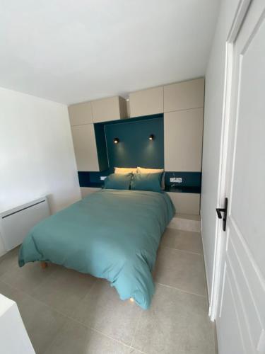 a bedroom with a bed with a blue headboard at Le Narlay in Le Frasnois