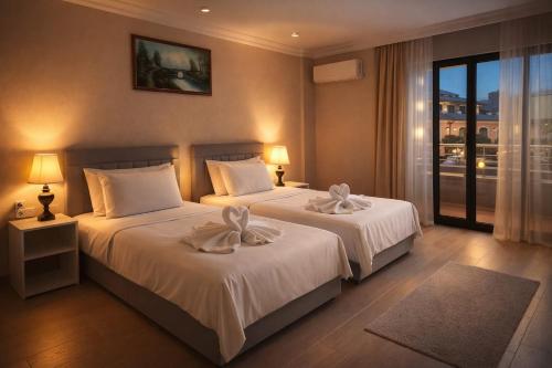 a hotel room with two beds with white sheets at Efes Artemis Hotel in Selçuk
