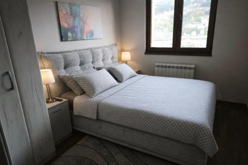 a bedroom with a large white bed with a window at Narcis in Užice