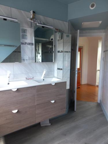a bathroom with two sinks and a large mirror at Maison de Crozon in Crozon