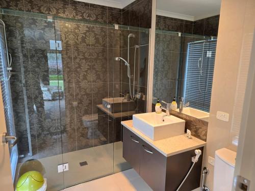 a bathroom with a shower and a sink and a mirror at River view in Shepparton