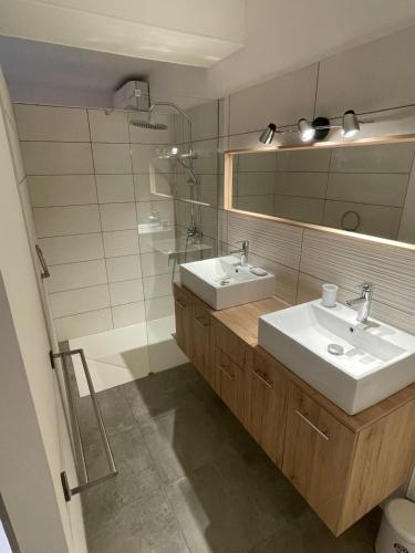 a bathroom with two sinks and a mirror at Les Marchettes in Saint-Nexans