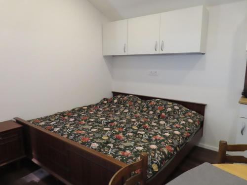a small bedroom with a bed with a floral bedspread at The Ramsons - Čemaž Glamping in Železniki