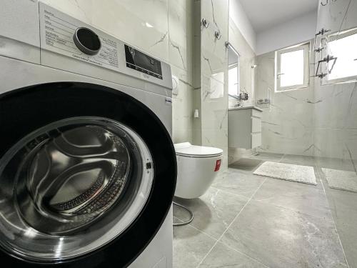 a washing machine in a bathroom with a toilet at 214 The Coastal Nest in Durrës