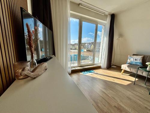 a living room with a tv and a large window at SELTEN Wasserblick Kölpinsee - Tolle Ferienwohnung unter 500m zur Ostsee Kajüte 12 in Kölpinsee