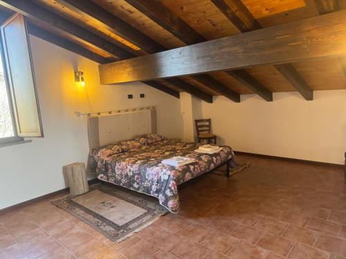 a bedroom with a bed in a room with wooden ceilings at Villa Cavalieri in Vedriano in Roncovetro