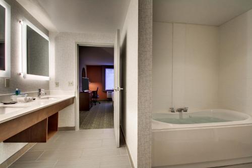 a bathroom with a tub and two sinks at Holiday Inn Express & Suites - Lincoln East - White Mountains by IHG in Lincoln