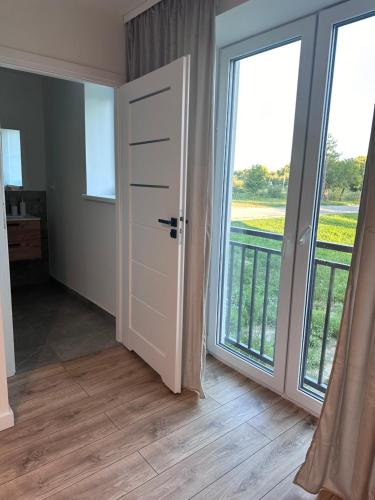 an empty room with a door and large windows at Apartament Ełcka 2- Mazury in Orzysz