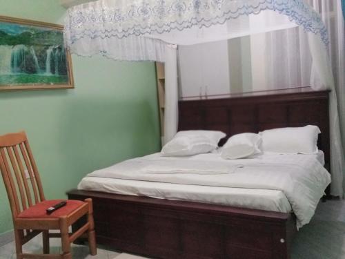 a bedroom with a bed with a canopy and a chair at BRACCK Suites in Nakwero