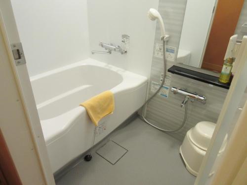 a bathroom with a bath tub and a toilet at Shiretoko Noble Hotel in Shari