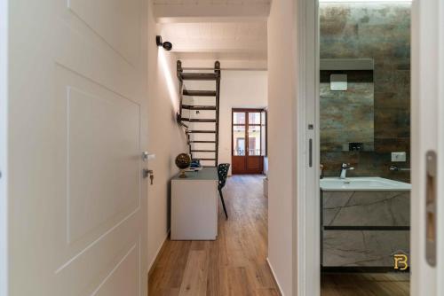 a hallway with a staircase and a bathroom with a sink at Identity By Rentbase in Cefalù