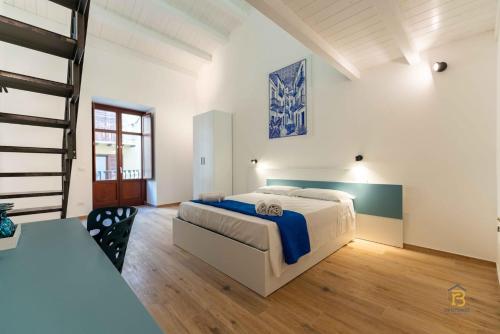 a large bedroom with a bed and a staircase at Identity By Rentbase in Cefalù