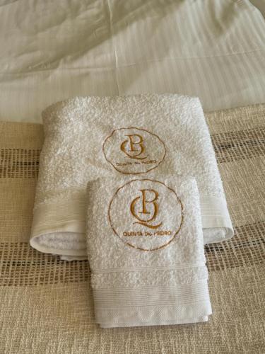 a couple of towels sitting on top of a bed at Quinta do Pedro in Luz de Tavira