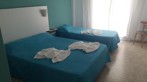 2 camas en una habitación con sábanas azules en Continente Park en San Clemente del Tuyú