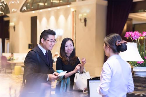 a group of people talking in a lobby at Mercure Xiamen Exhibition Centre in Xiamen