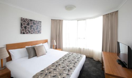 a hotel room with a bed and a television at The Sebel Sydney Chatswood in Sydney