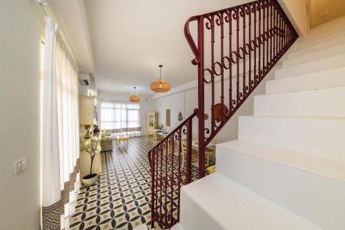 a hallway with a staircase with a stair railing at NG Guest House Ammentos in Olbia