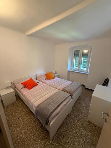 a bedroom with a bed with orange pillows on it at Appartamento LUNA in Mele