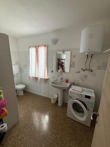 a small bathroom with a washing machine and a sink at Appartamento LUNA in Mele