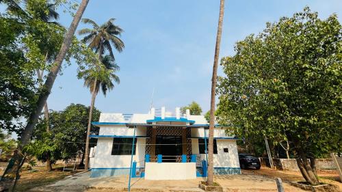 a house with palm trees in front of it at Arabian Shore - Udupi in Malpe