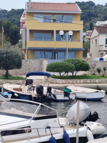 a group of boats docked in the water near a building at Blue Pearl Seafront in Preko