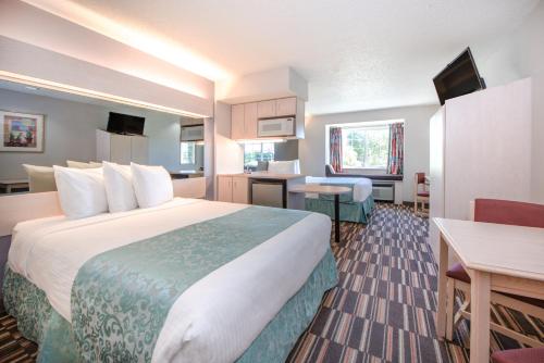 a hotel room with a large bed and a desk at Microtel Inn & Suites Claremore Route 66 in Claremore