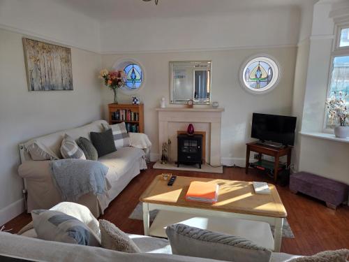 a living room with a couch and a fireplace at Cosy Bournemouth Bungalow in Longham