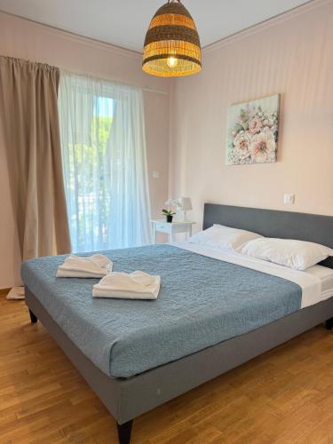 a bedroom with a bed with two towels on it at Sun Beach Apartment in Anavyssos